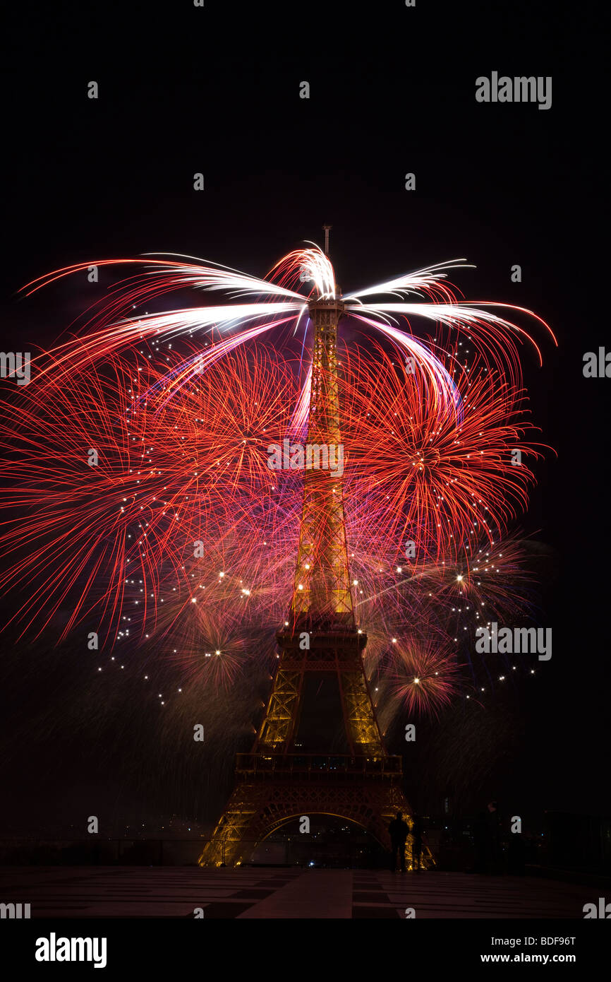 Bastille Day fireworks Eiffel Tower Paris France independence celebration small silhouette gendarme at tower base adds perspective editorial use only Stock Photo