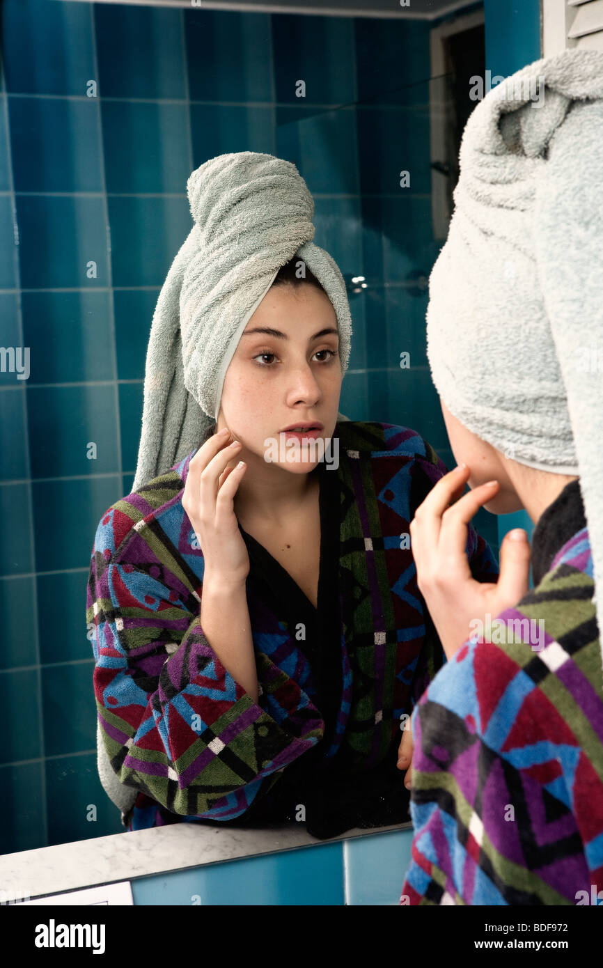 Girl after shower looking her face in a mirror Stock Photo Alamy