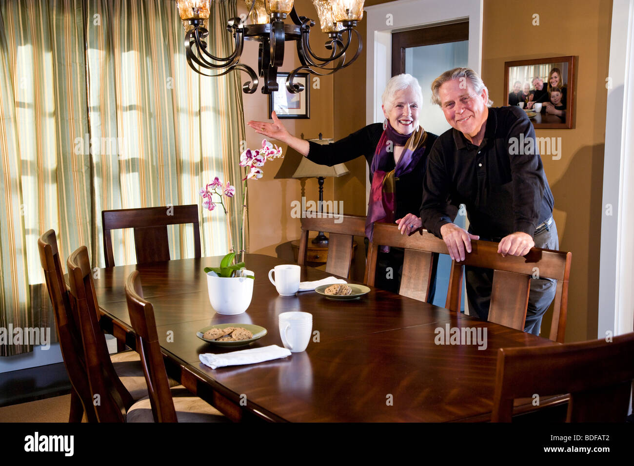 Happy senior couple standing in dining room of home Stock Photo