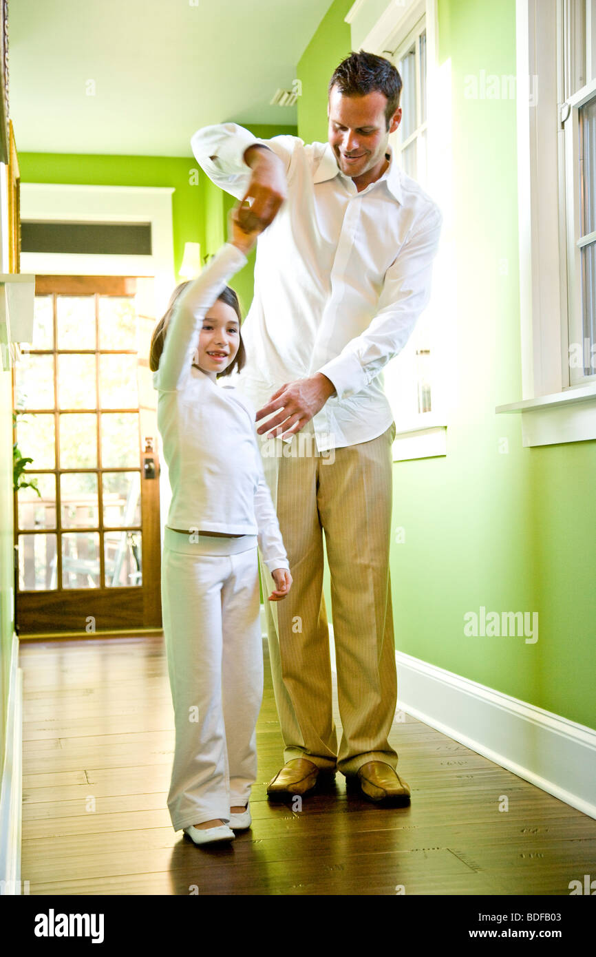 Father and daughter standing in hallway of house Stock Photo