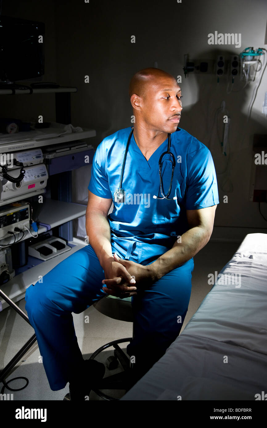 AfricanAmerican doctor in scrubs sitting in hospital room Stock Photo