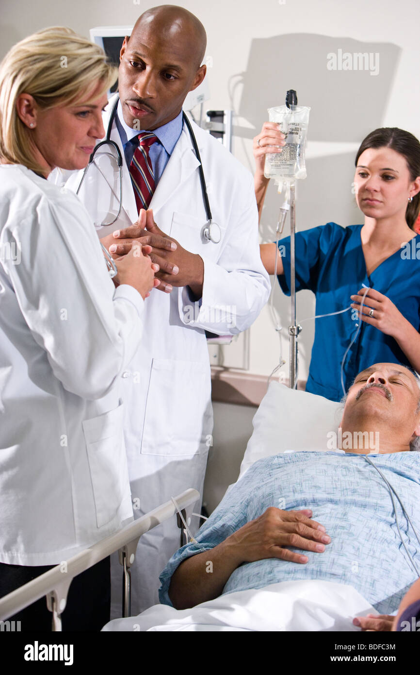 Doctors and nurse in hospital room with patient Stock Photo Alamy
