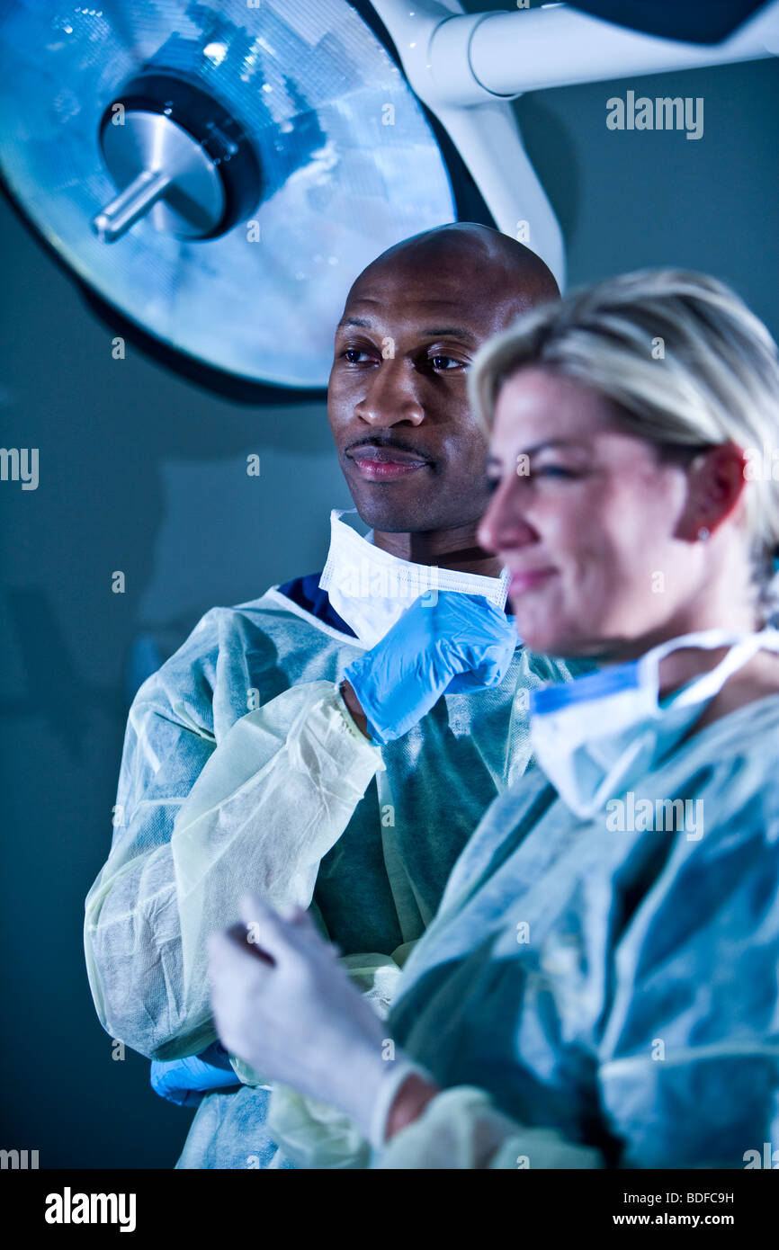 Multiethnic doctors in surgical scrubs in hospital room Stock Photo