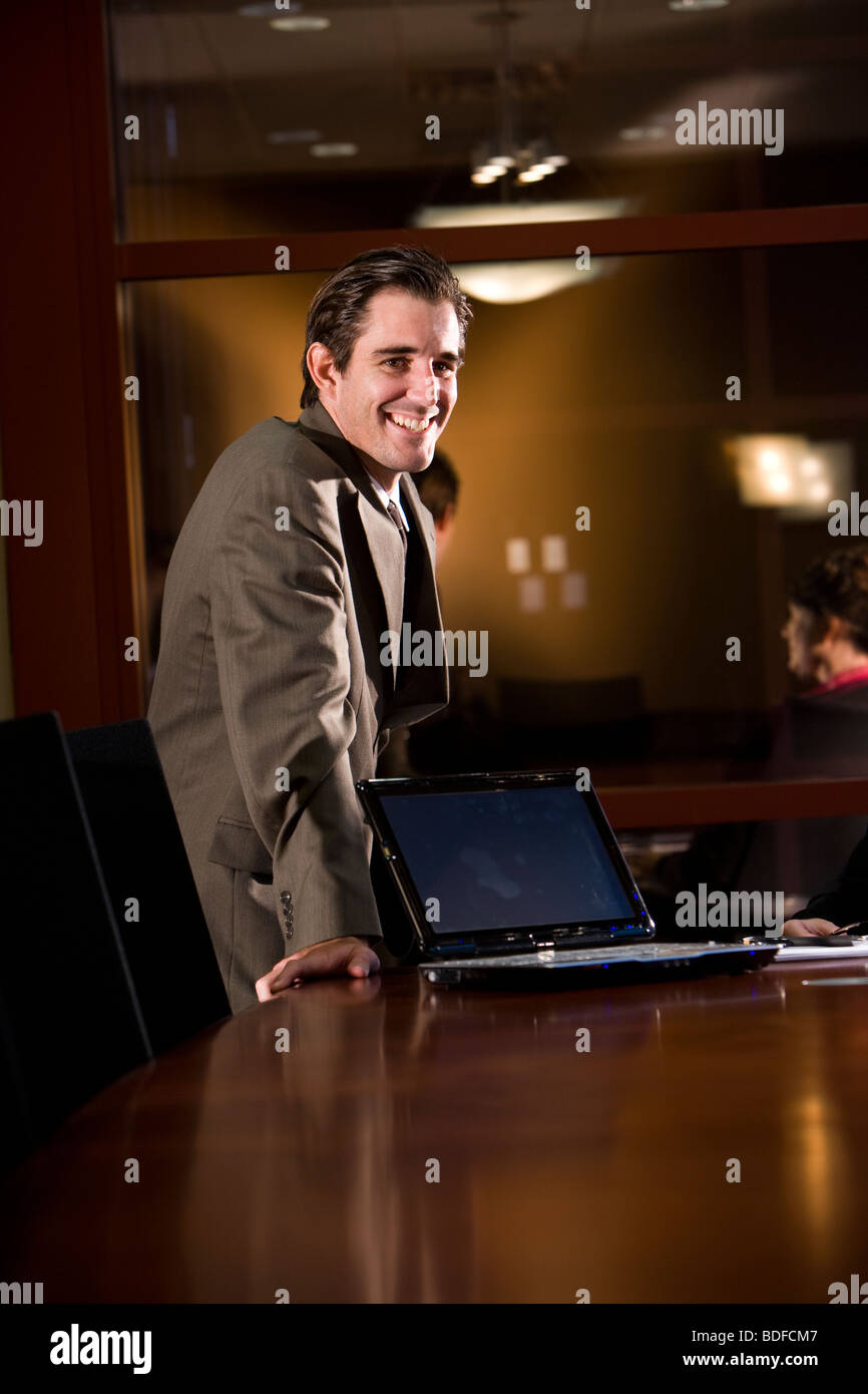 Portrait of smiling businessman with laptop in office Stock Photo - Alamy