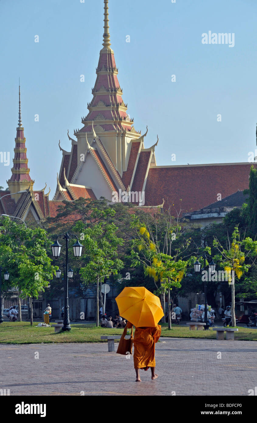 Monk with an umbrella in front of the Silver Pagoda, Phnom Penh, Cambodia, Asia Stock Photo