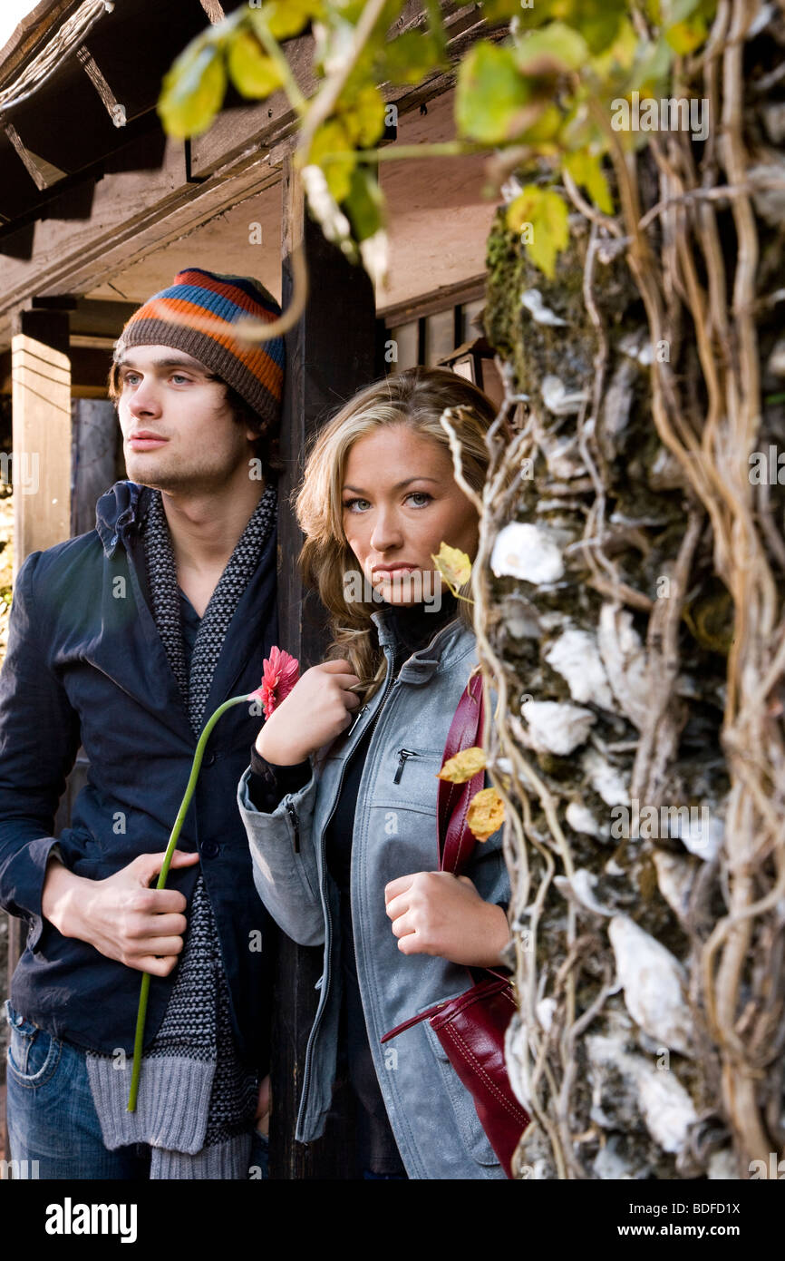 Young couple standing outside wooden building Stock Photo - Alamy