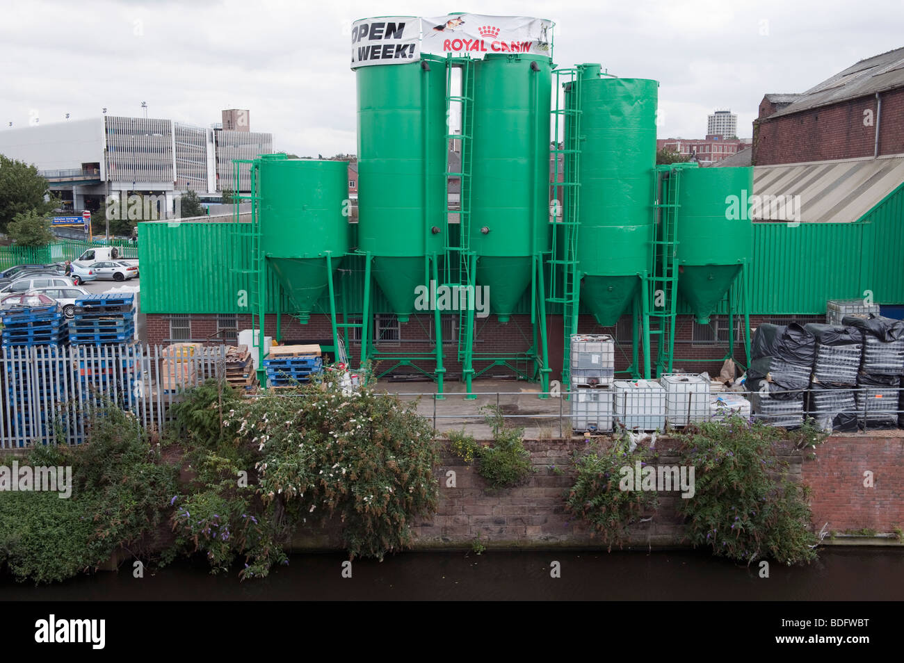 Green dry silo containers on the rear of a retail park building Stock Photo
