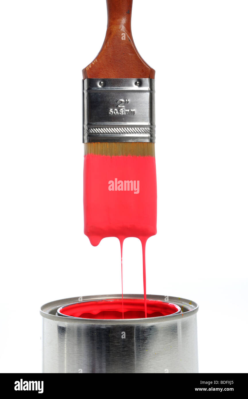 Brush dripping red paint into an open can Stock Photo