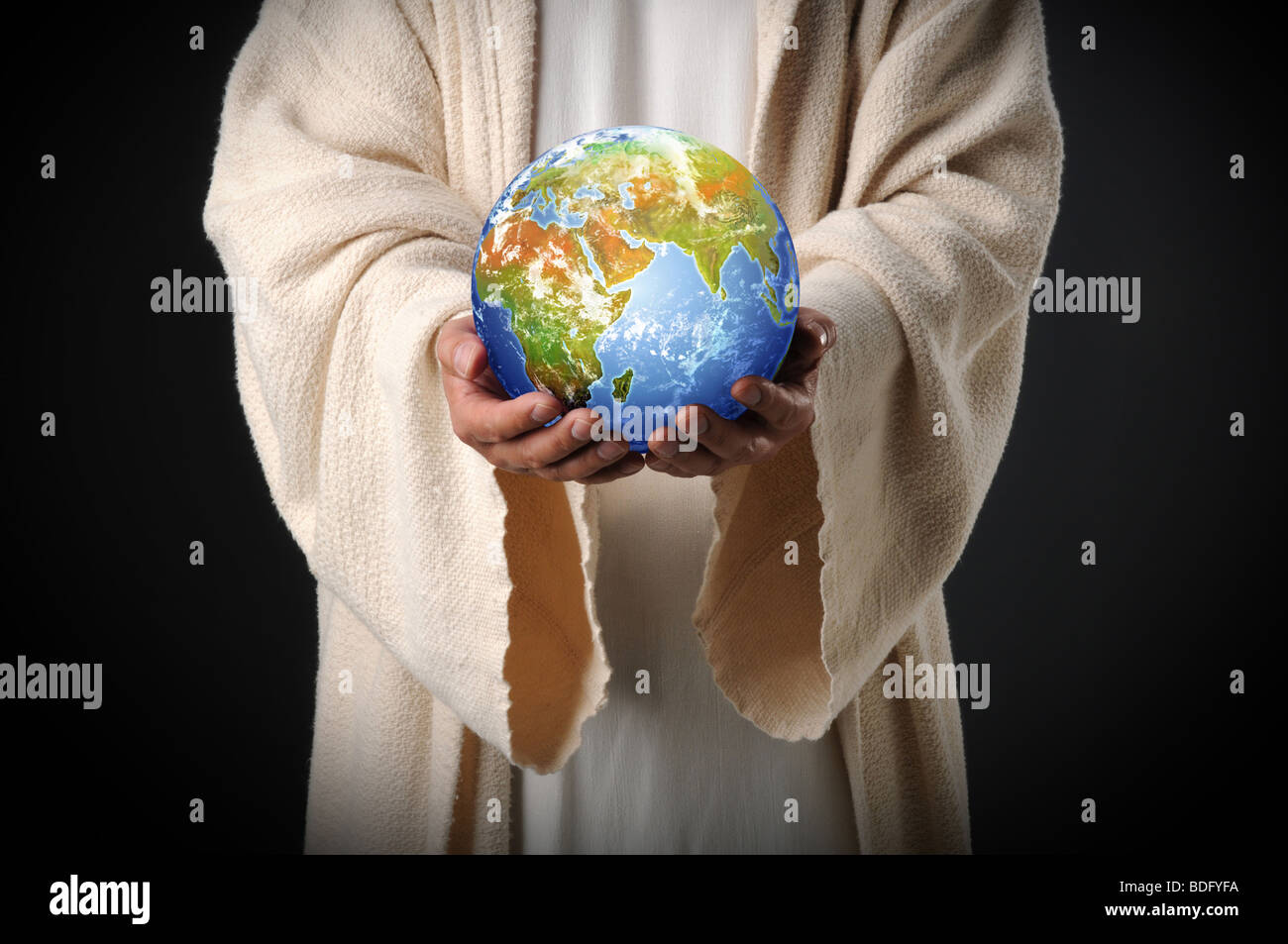 Jesus holding the world in his hands over a dark background Stock Photo
