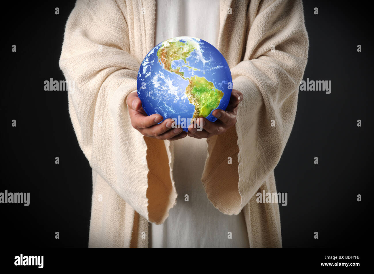 Hands of Jesus holding world in hands over dark background Stock Photo