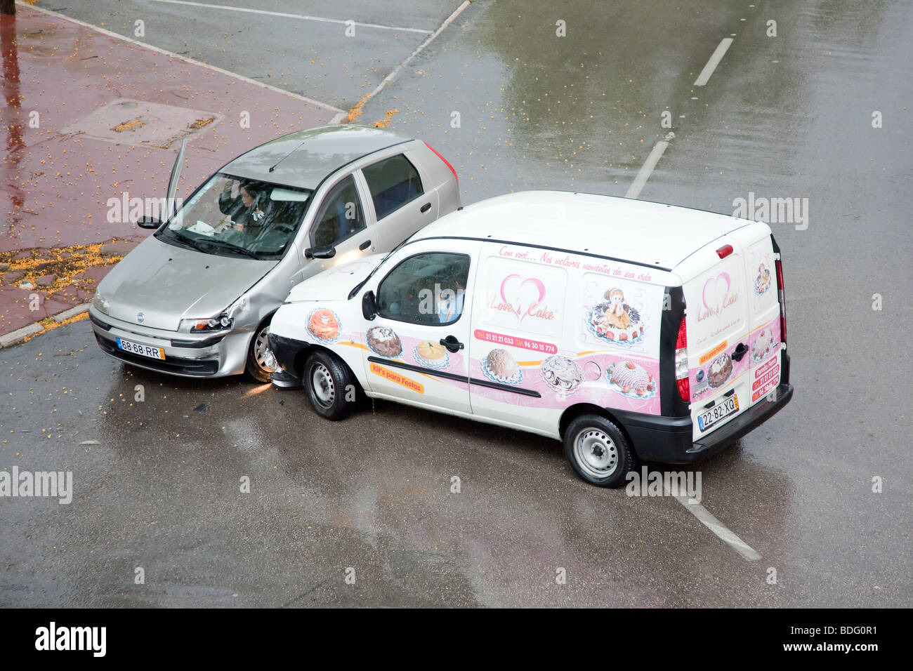 Two women (drivers) during a car accident on a rainy day due to excessive speed. Stock Photo