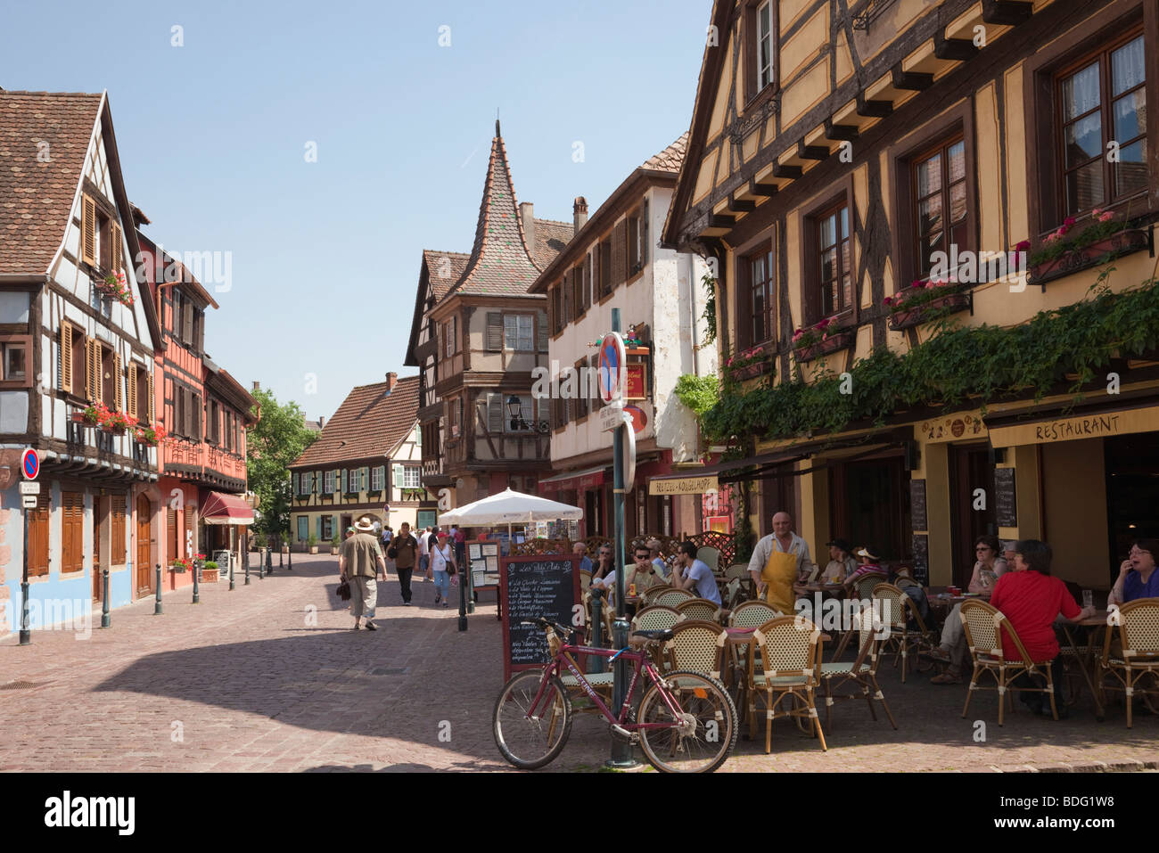 Street scene with pavement cafe in medieval town on the Alsatian wine route. Kaysersberg, Alsace, Haut-Rhin, France, Europe. Stock Photo