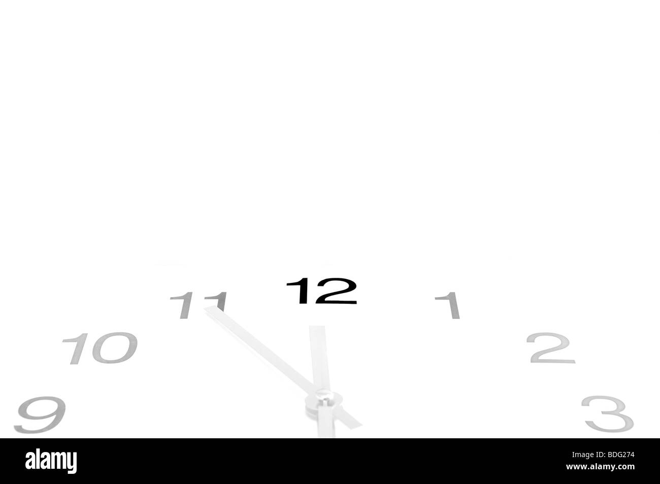 Clock showing the time of five-to-twelve, conceptual for it being almost high noon, free space for text Stock Photo
