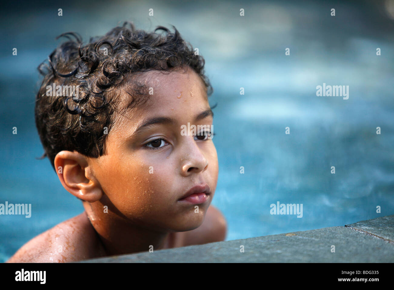 8 year old boy in a backyard swimming pool Stock Photo