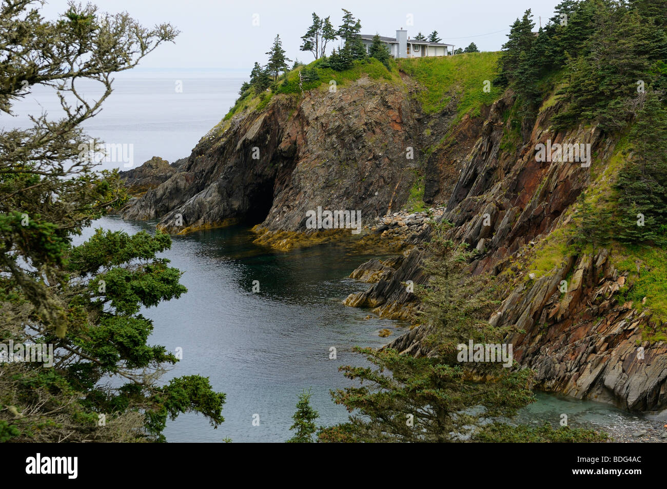 House above the sea cliffs and cave of Smugglers Cove Provincial Park Nova Scotia Stock Photo