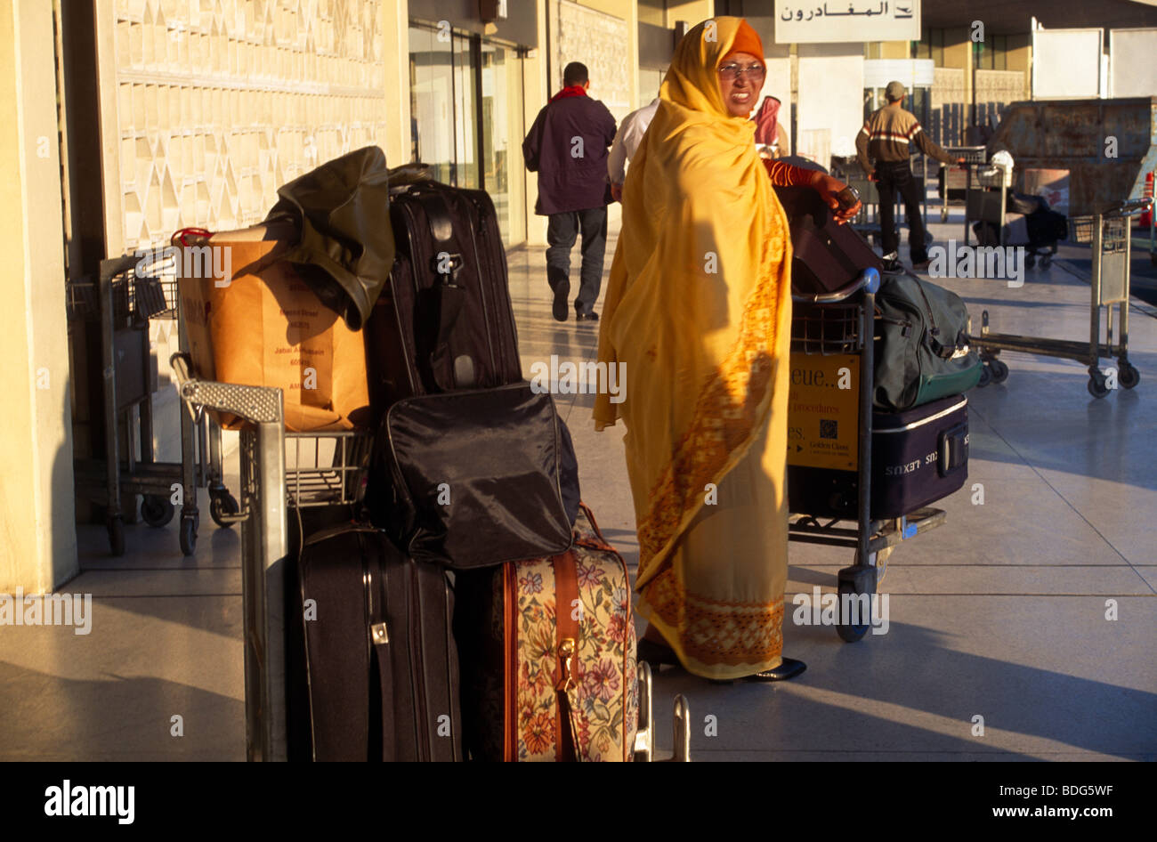 Abu Dhabi UAE Woman With Suitcases Outside Airport Stock Photo