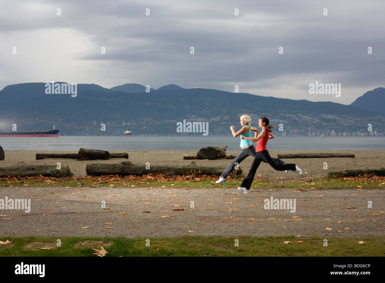 Two young women jogging along Spanish Bank Beach in Vancouver, British