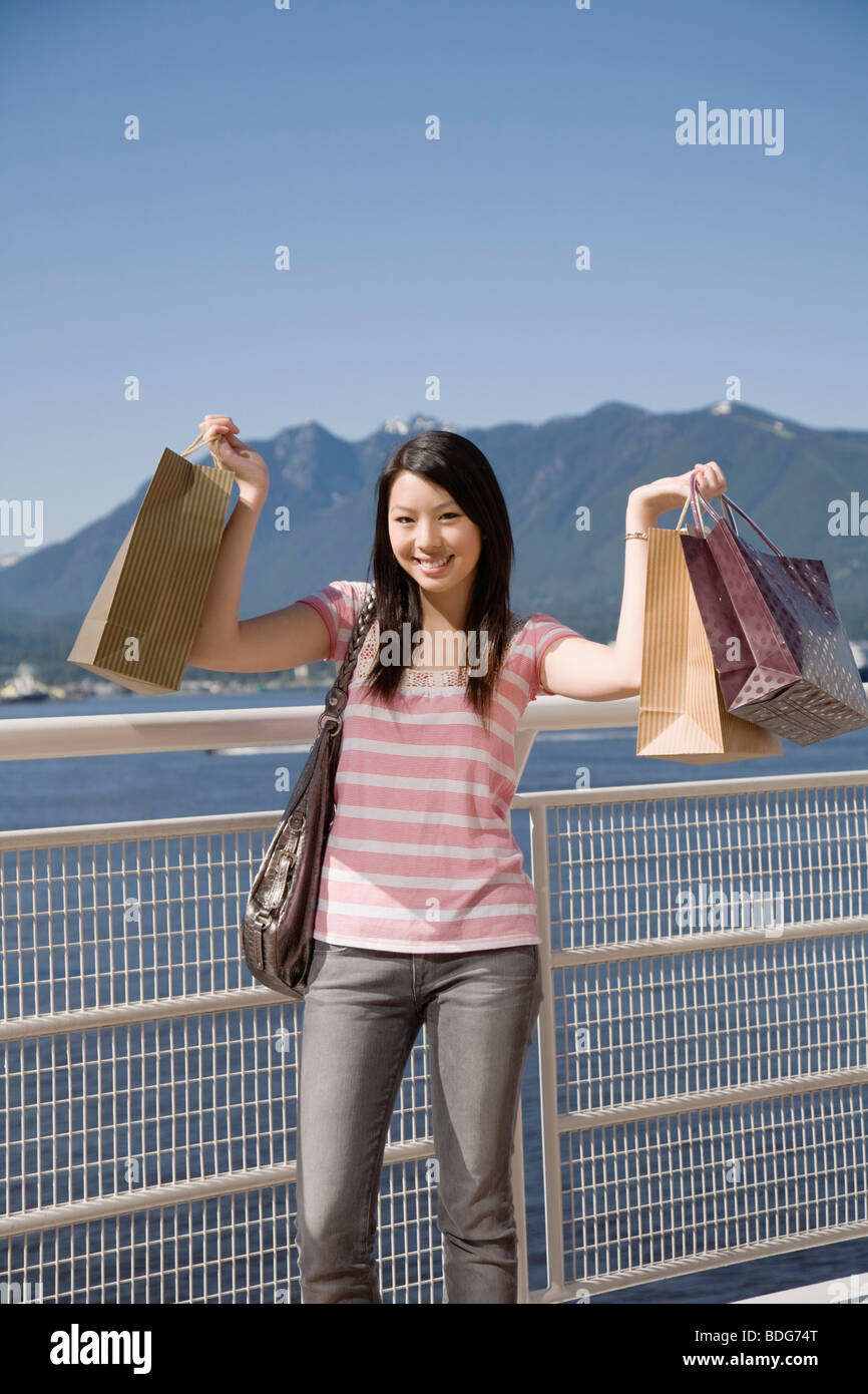 A young woman poses with shopping bags at Canada Place, Vancouver