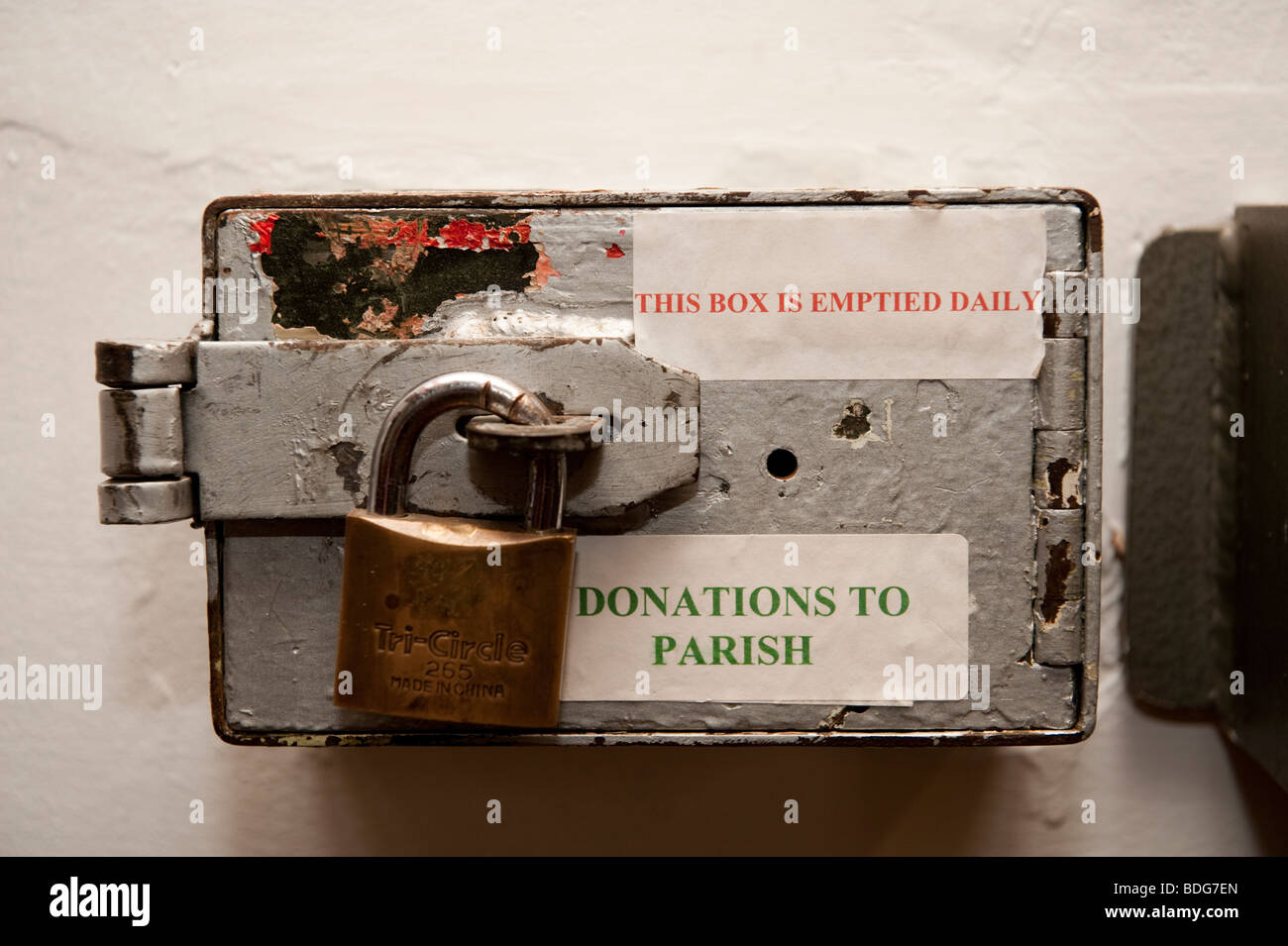 A Padlocked parish church donations money box UK "this box is emptied daily" Stock Photo