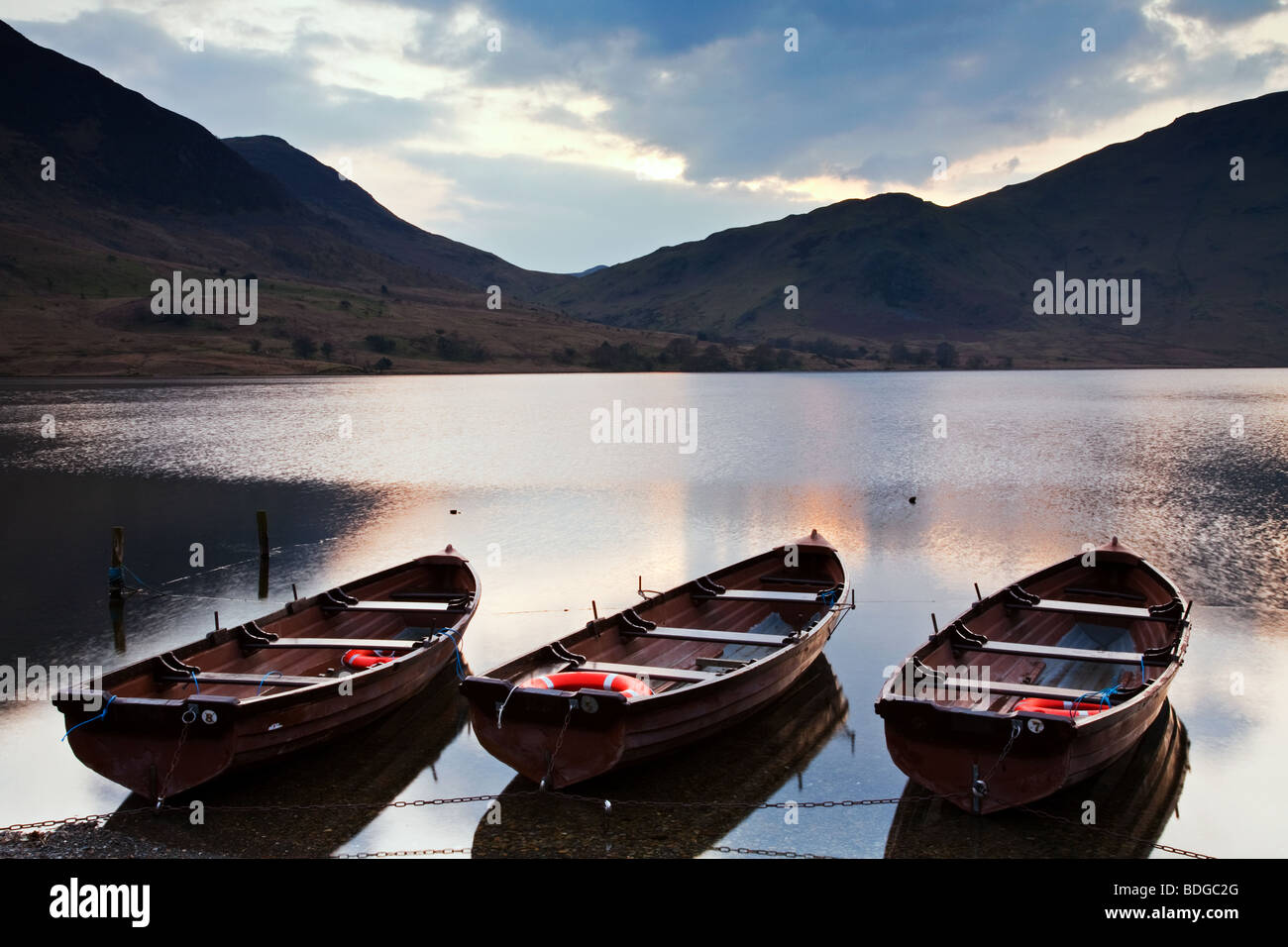 Three boats moored at dusk on Crummock Water Stock Photo