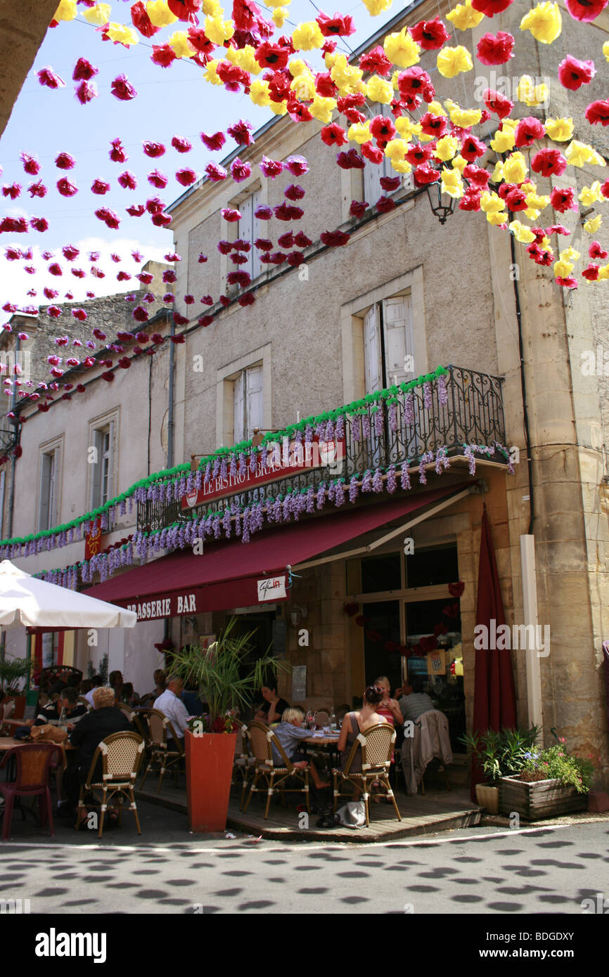 People enjoying lunch on the terrace of a cafe restaurant in the main square of  Beaumont du Perigord Stock Photo