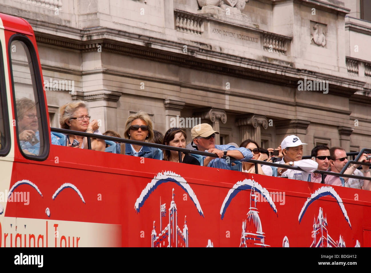 Tourists on top of a London sightseeing bus looking at and taking photographs of Tower Bridge Stock Photo