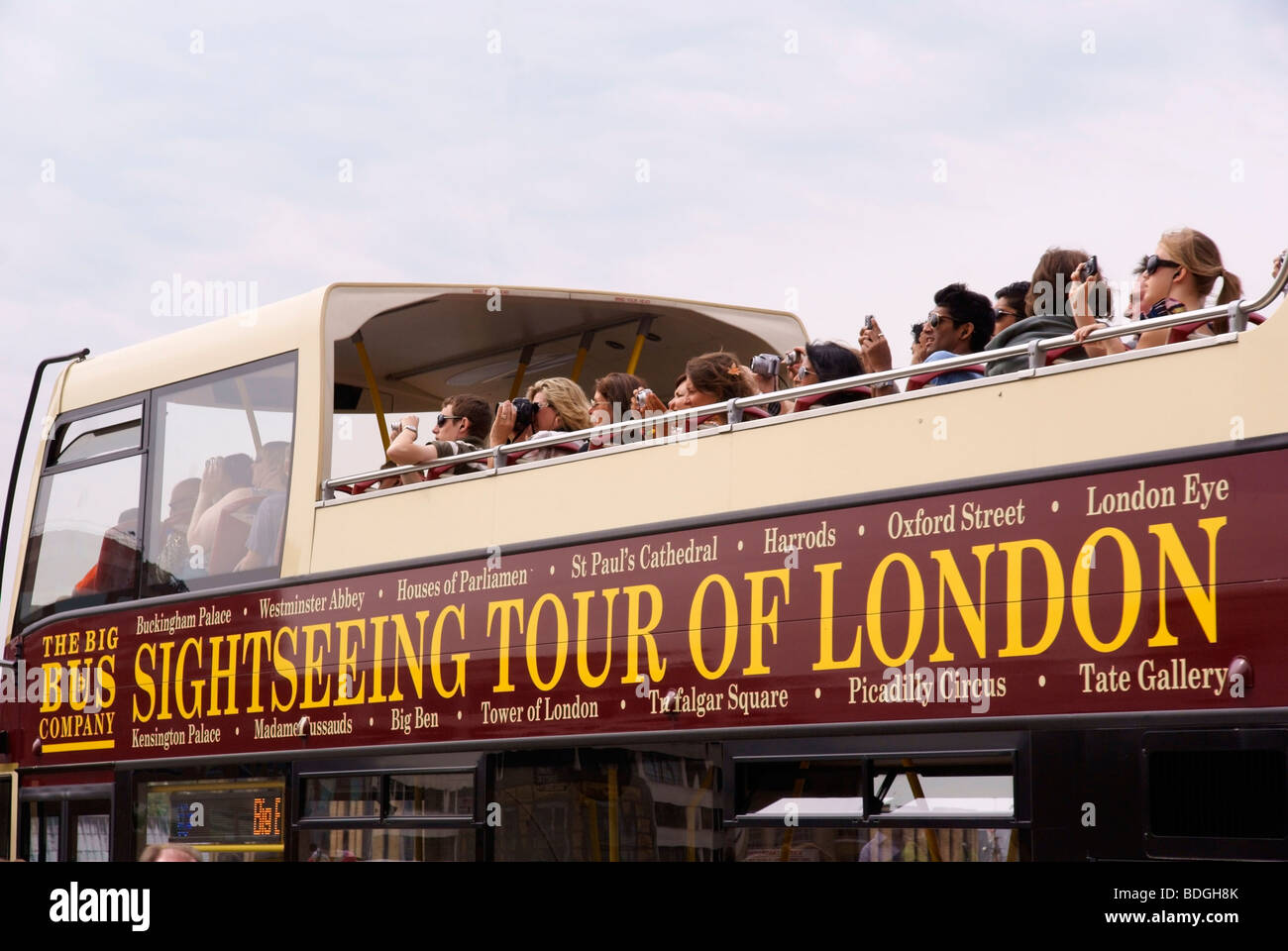 Tourists on top of a London sightseeing bus looking at and taking photographs of Tower Bridge Stock Photo