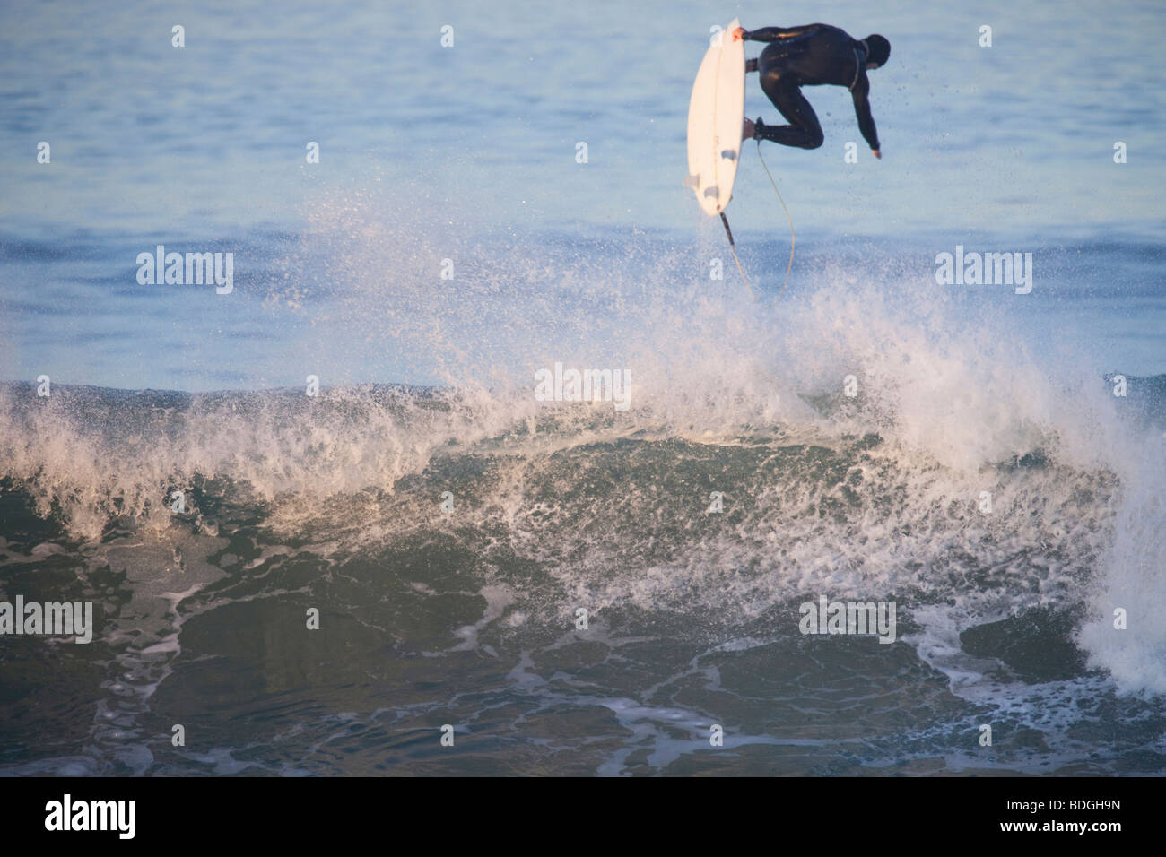 Surfer catching air off the top of a wave. Stock Photo