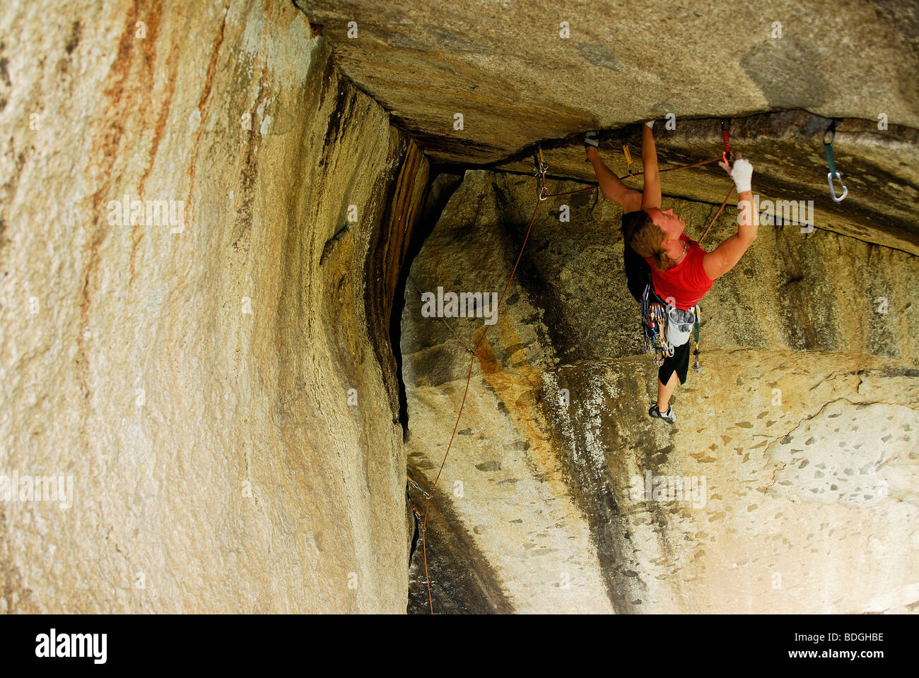 A woman gripping an overhang while rock climbing in Yosemite Valley