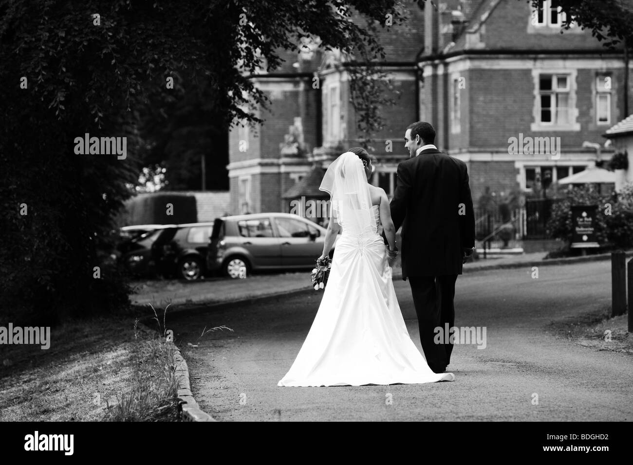 Natural reportage documentary photo of Bride and groom walking towards wedding hotel reception on wedding day UK Stock Photo