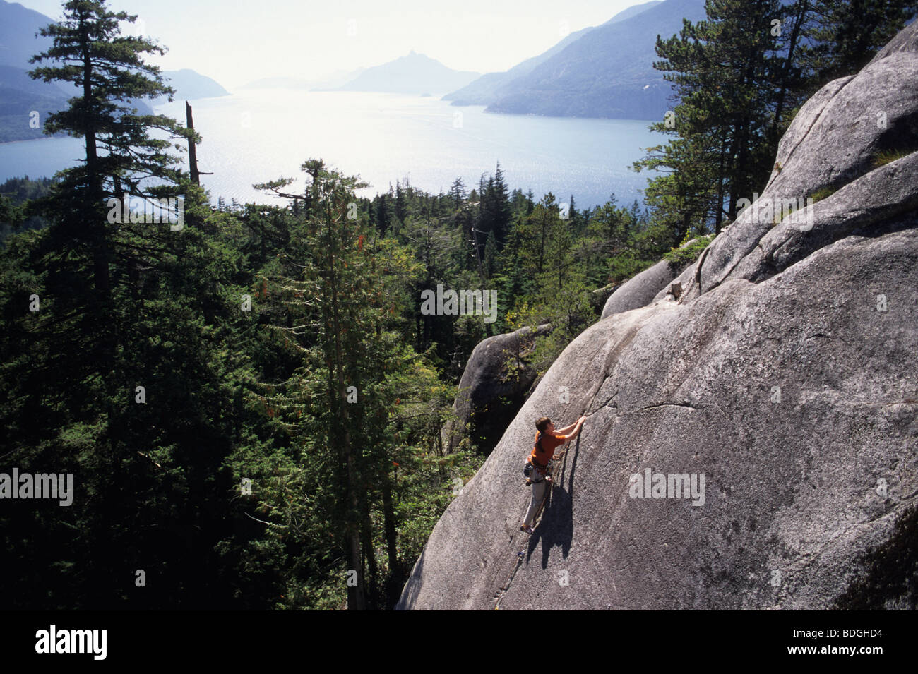 A man rock climbing with water in the background in Squamish, British Columbia, Canada. Stock Photo