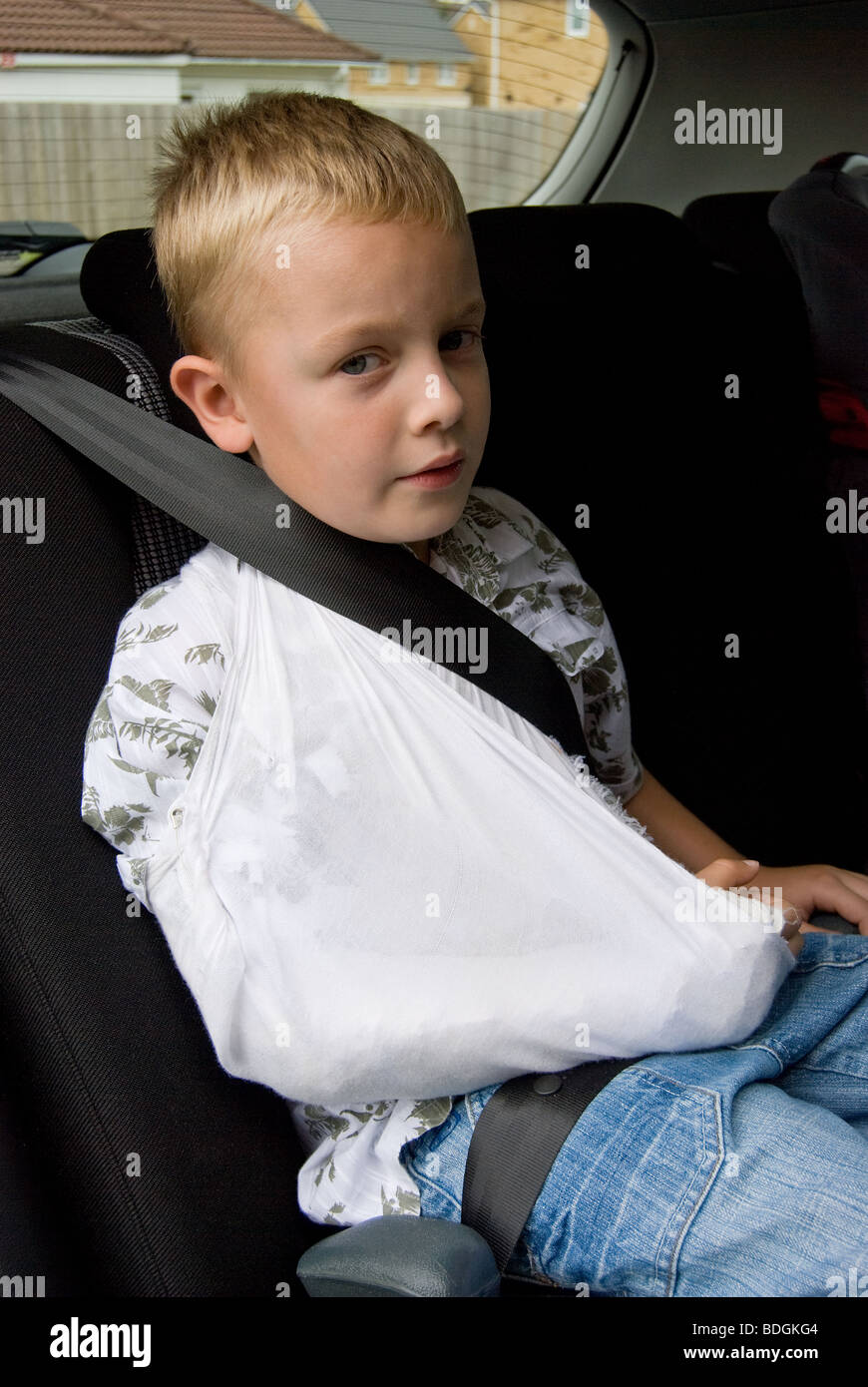 Boy sitting in a car with a broken arm Stock Photo Alamy