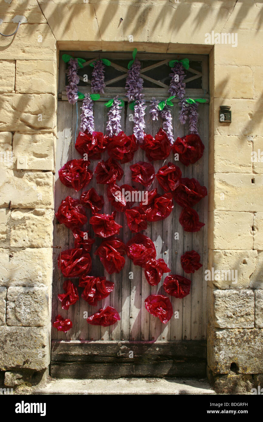 Door festooned with flowers in Beaumont du Perigord during the summer's