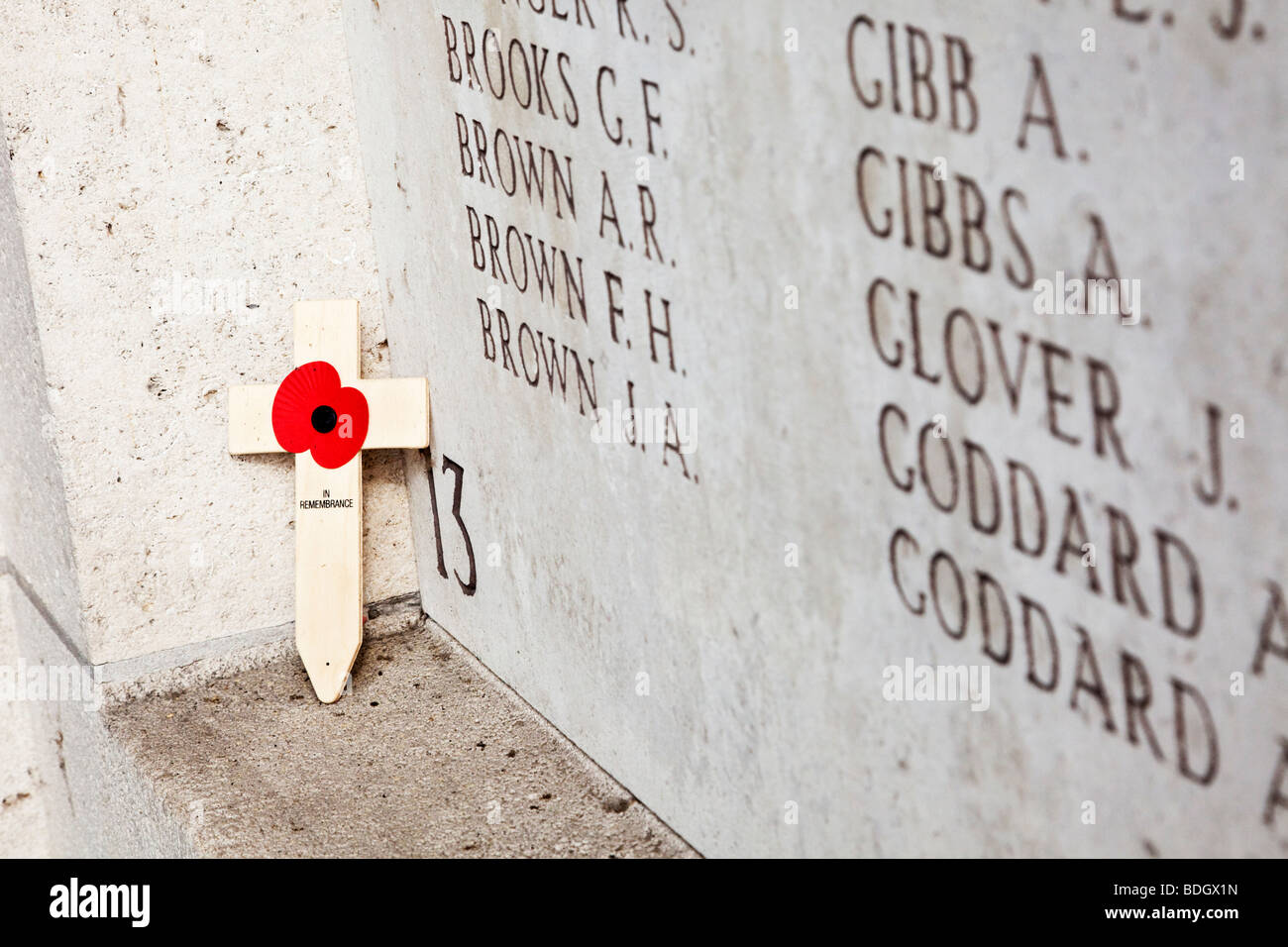 Lone poppy cross left on a wall bearing names of missing soldiers at the Menin Gate WW1 memorial at Ypres, Belgium, Europe Stock Photo