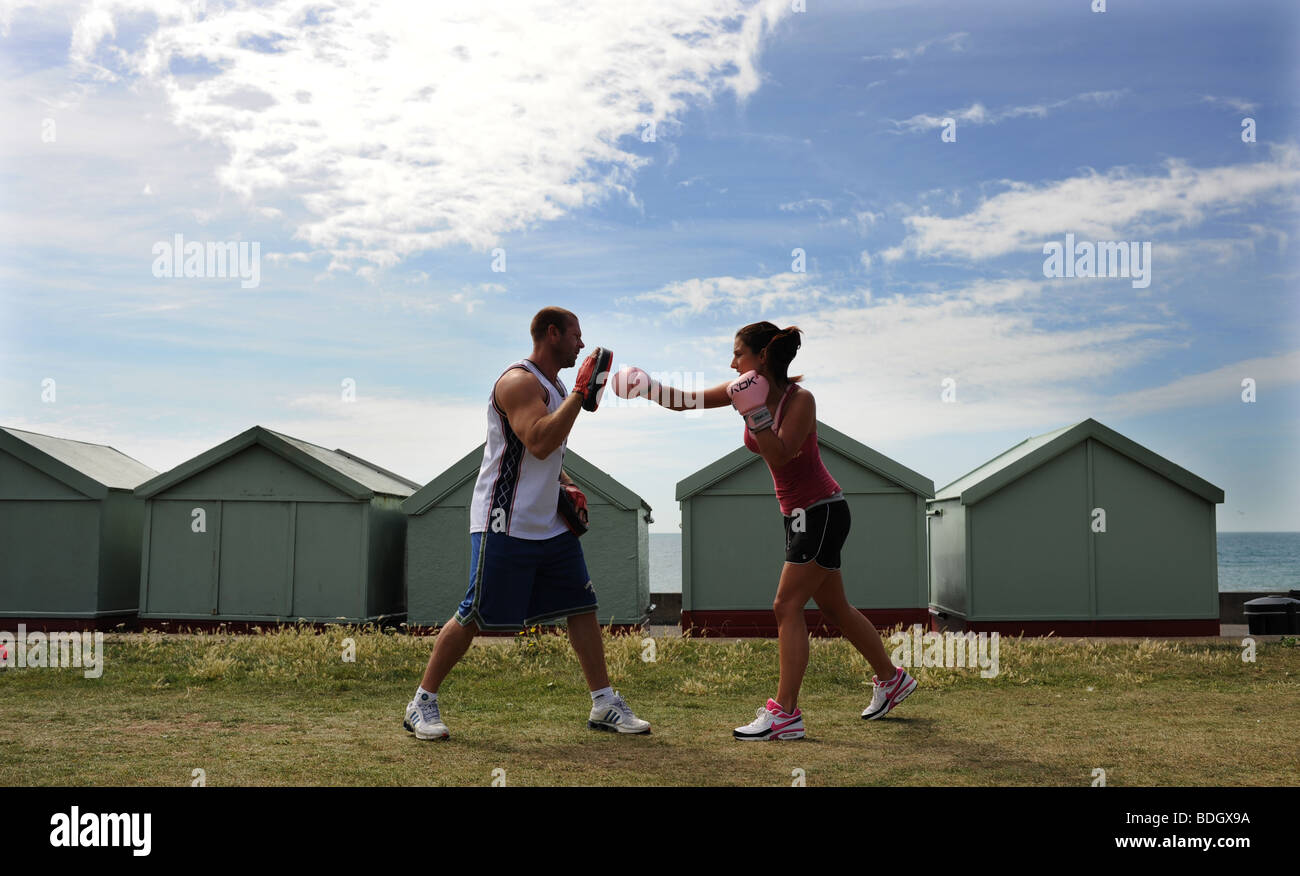 Couple keep fit boxing together on Hove Lawns Brighton Sussex UK Stock Photo