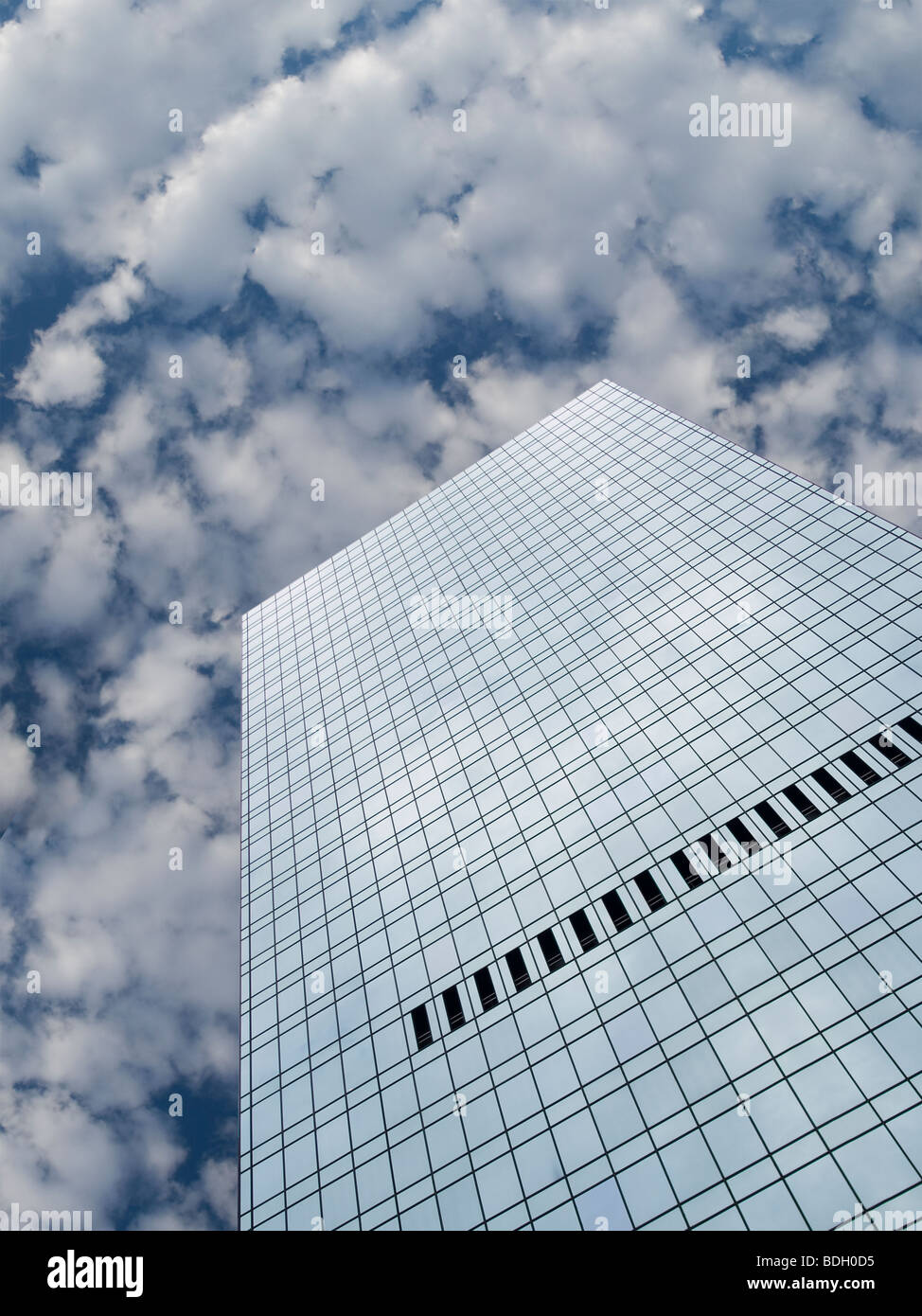 High modern skyscraper on a background of a blue sky and clouds. Stock Photo