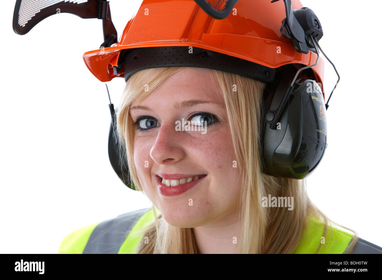 young 20 year old blonde woman smiling wearing orange hard hat ear protectors visor and high vis vest Stock Photo