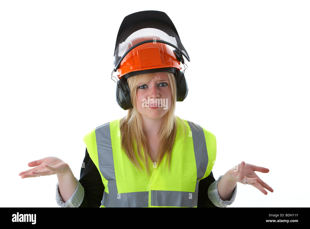 young 20 year old blonde woman with hands out confused wearing orange hard hat ear protectors visor and high vis vest hands outstretched in dont know Stock Photo