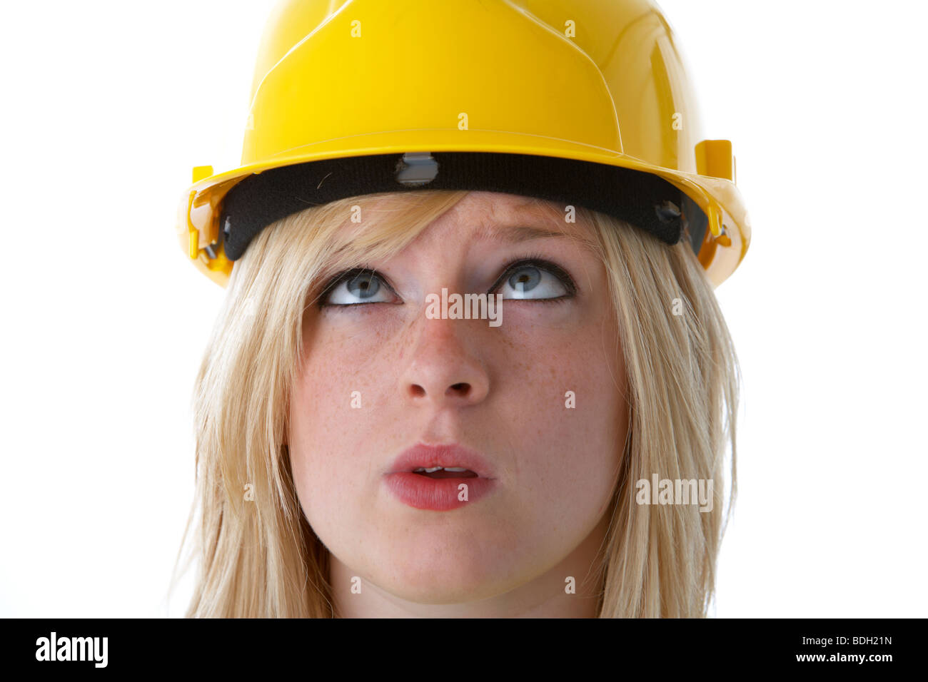 Young 20 year old blonde woman wearing yellow hard hat looking up