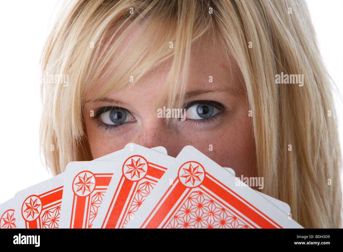 young 20 year old blonde woman holding five large playing cards over her face Stock Photo