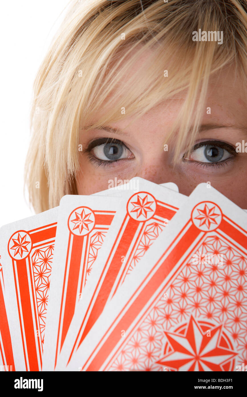 young 20 year old blonde woman holding five large playing cards over her face Stock Photo