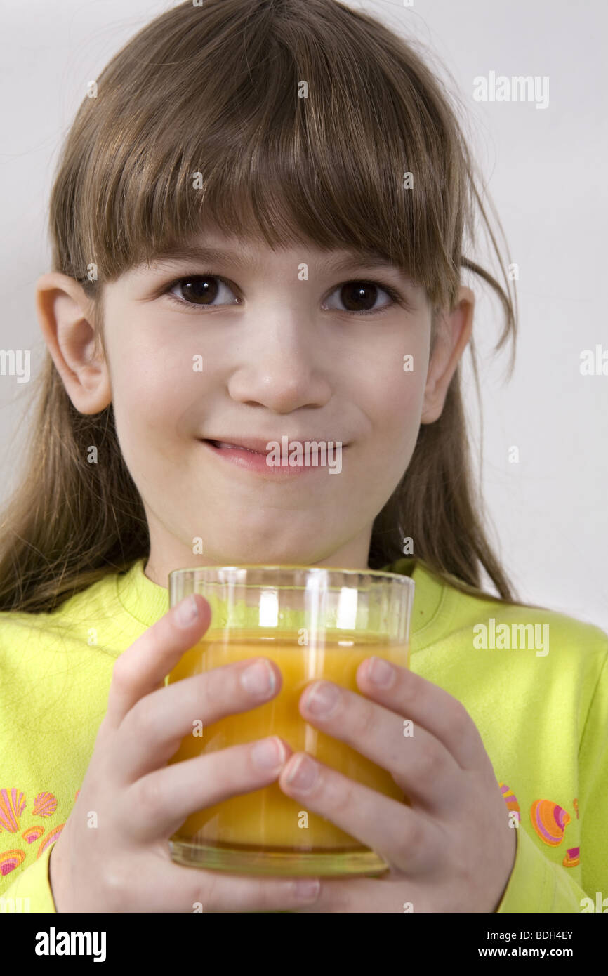 little cute adorable girl seven years old drink orange juice Stock