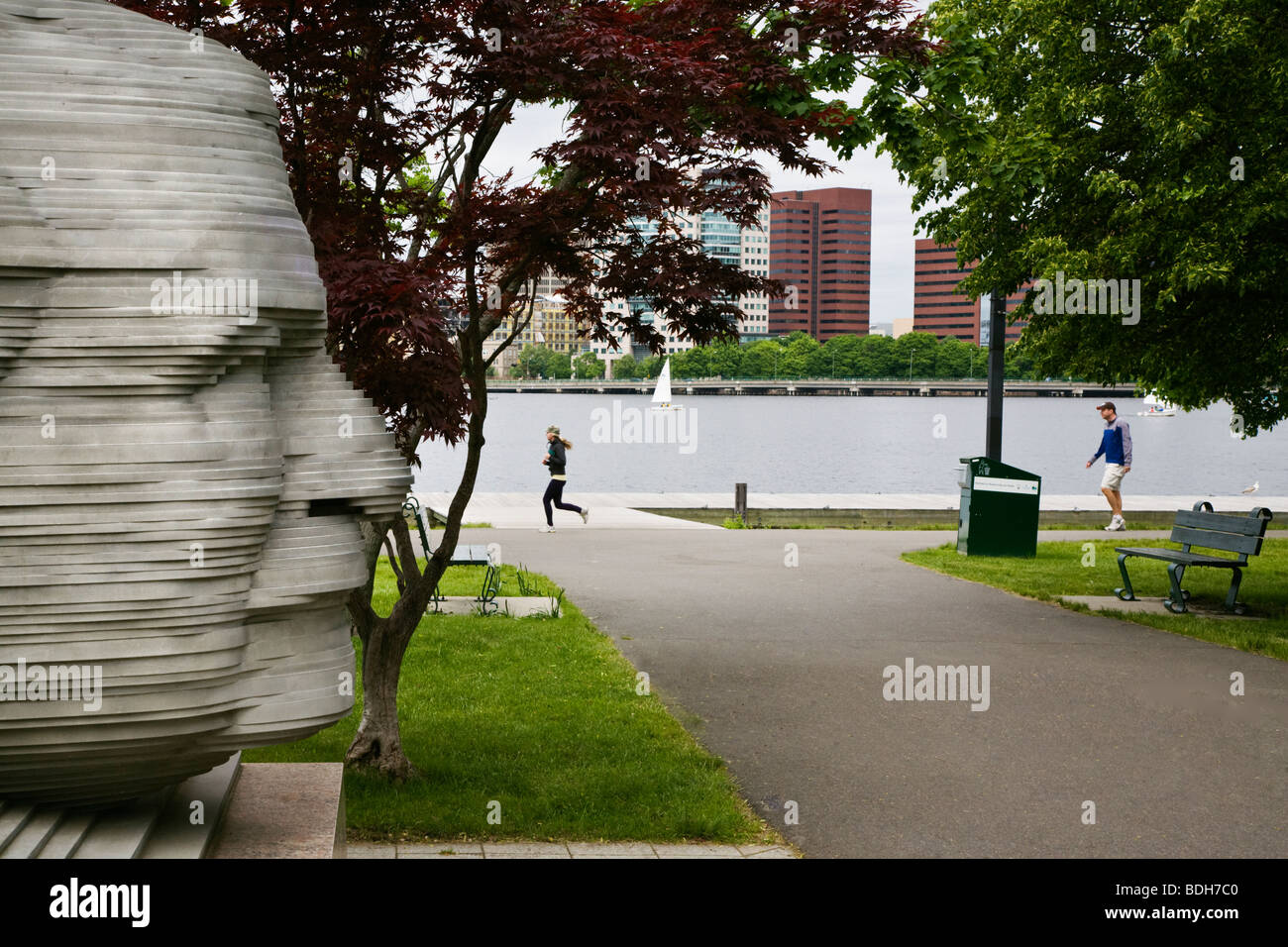 Joggers pass a statue of ARTHUR FIEDLER the conductor of the Boston Pops orchestra in CHARLES RIVER PARK - BOSTON, MASSACHUSETTS Stock Photo