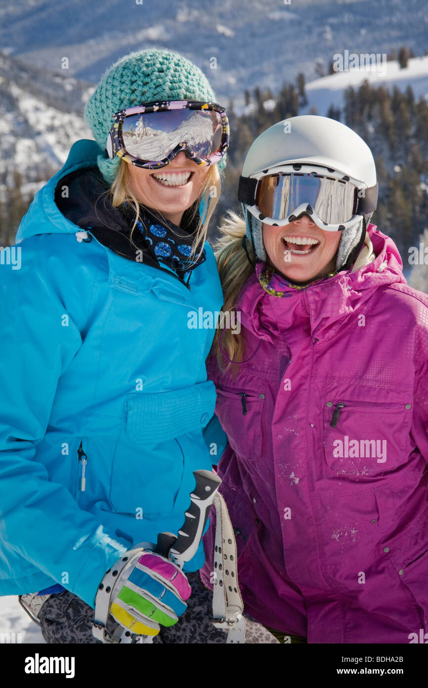 Two female skiers in helmets smiling and having fun on the ski slopes. Stock Photo