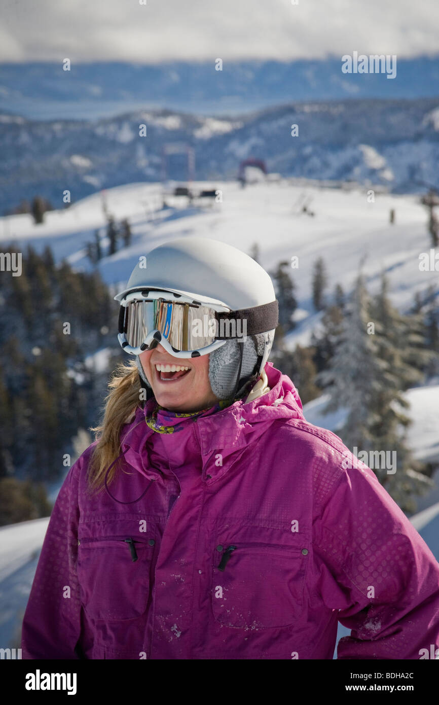 A female skier in a helmet smiling and having fun on the ski slopes. Stock Photo