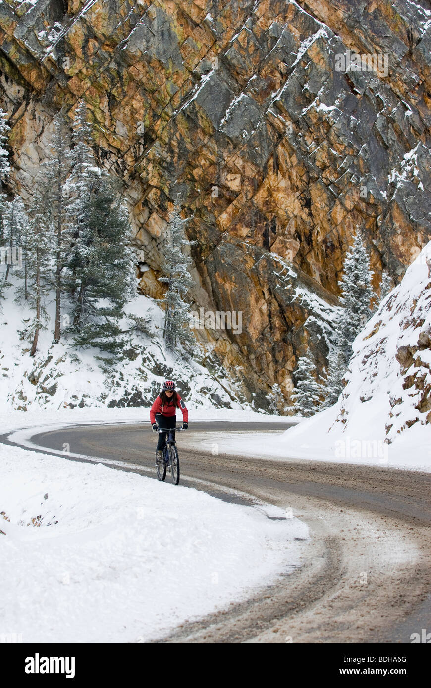 A woman riding her bike in the winter up Red Mountain Pass, Ouray