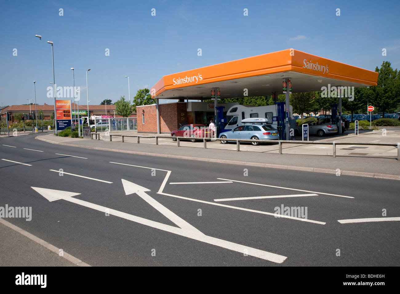 Cars and a motorhome filling up with fuel at a sainsburys petrol station in England. Stock Photo