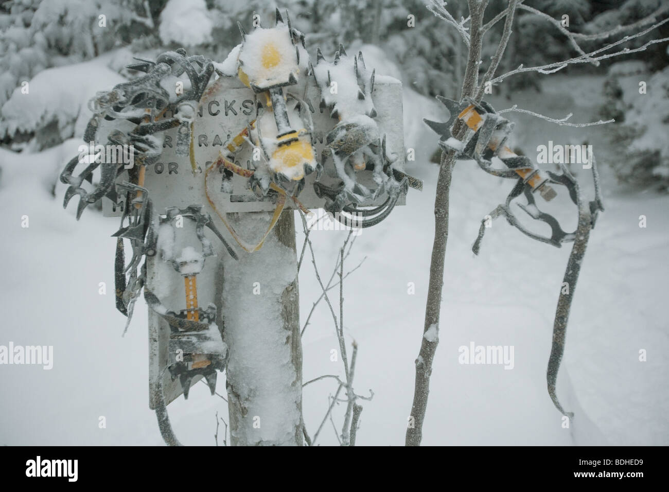 Crampons hang on a trail sign near a mountain cabin at the North end of the Presidential Range in New Hampshire. Stock Photo