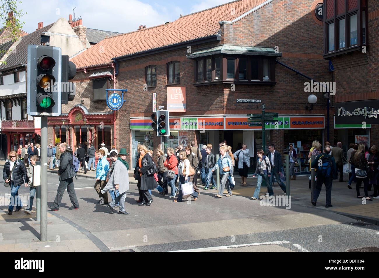 Pedestrians crossing the road at traffic lights in York city centre, England Stock Photo