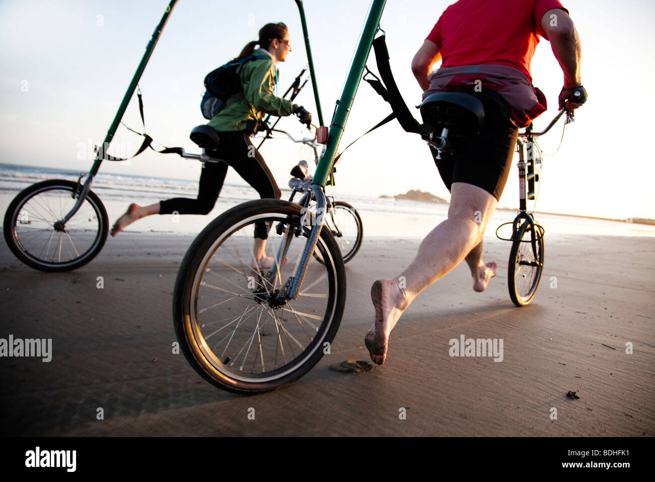 A new form of bicycle is tested on the beach at sunset. Stock Photo